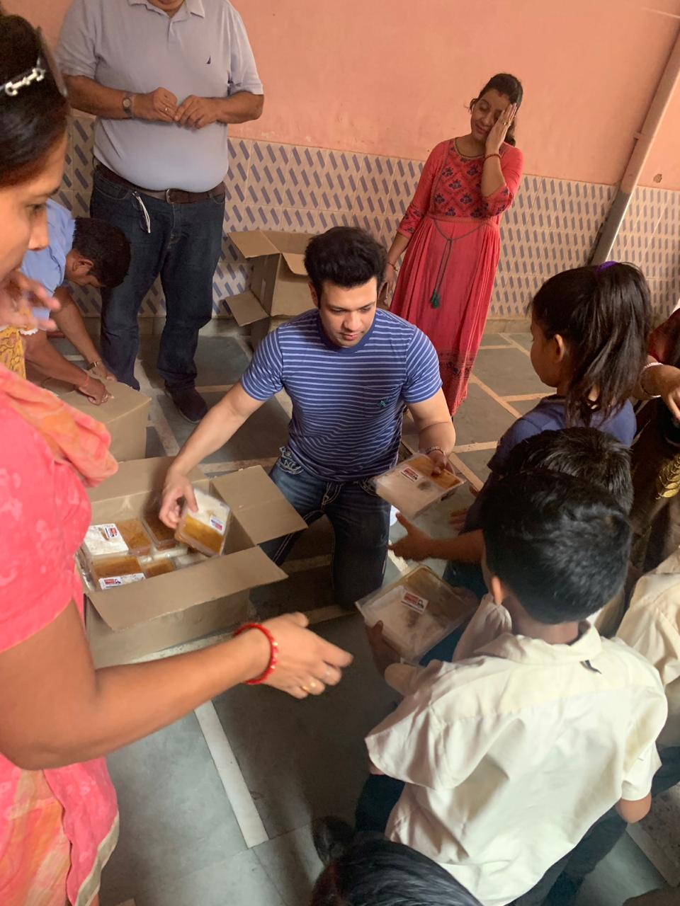 Musician Amaan Ali Bangash hands out meals to children supported by the foundation