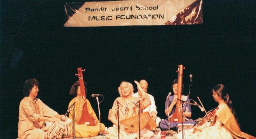 Photograph taken at centennial theatre, North Vancouver in 1996. Pandit Jasraj with Ustad Zakir Hussain on the tablas and Kala Ramnath on the violin. On the tanpuras  - Asha Lohia and Vasu S