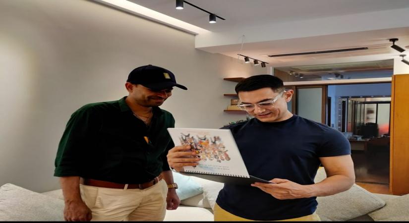 Cartoonist Manoj Sinha presenting a copy of the calendar to actor Aamir Khan.