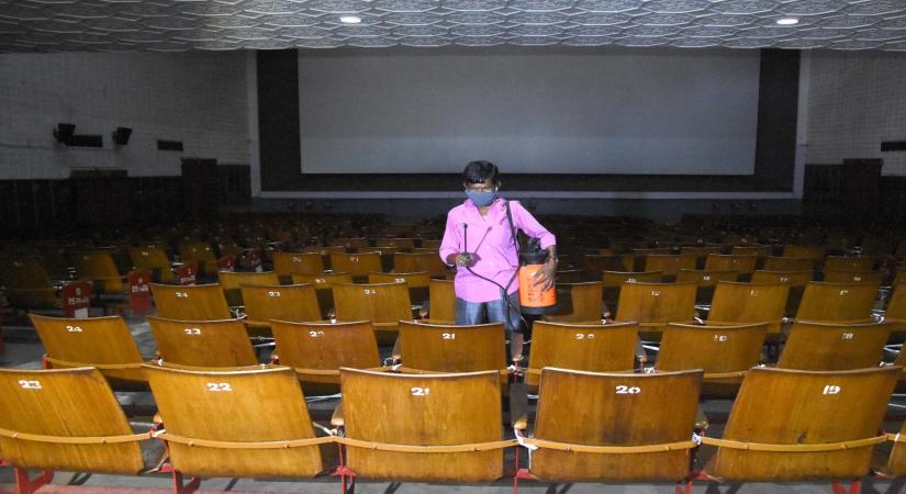 Bengaluru:  A worker sanitises a cinema hall ahead of its reopening as part of Unlock 5.0 amid measures against COVID-19, in Bengaluru on Oct 15, 2020. (Photo: IANS)