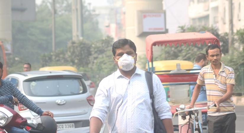 People wear masks to protect themselves from air pollution as smog continues to engulf the national capital, on Nov 4, 2019. (Photo: IANS)