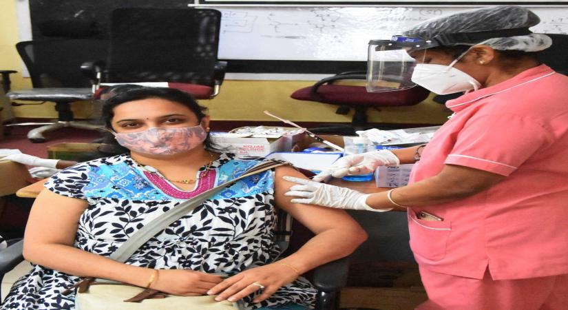Health workers administering the COVID-19 vaccine to people during COVID-19 vaccination drive at KC General Hospital and some people waiting during COVID-19 vaccination drive in Bengaluru on Sunday 23 May 2021.  (Photo: IANS)