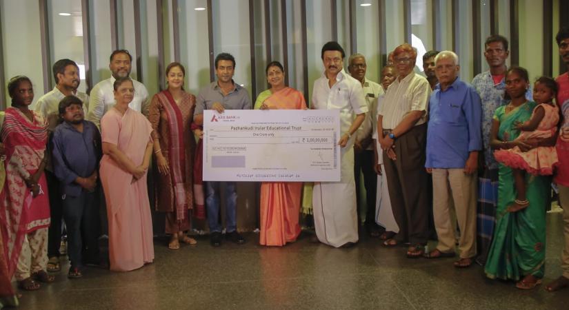 Suriya handing over cheque to Irular.
