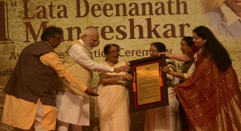 Mumbai : Prime Minister Narendra Modi being presented a memento by Singer Asha Bhosle, Usha Mangeshkar and Hridaynath Mangeshkar during the 1st Lata Deenanath Mangeshkar Award ceremony  in Mumbai on Sunday April 24, 2022. (Photo: Nitin Lawate/IANS)
