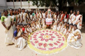 An artist accompanied by women dressed in traditional attire, performs Kathakali around pookalam (flower rangoli) during Onam celebrations in Chennai on Sep 10, 2019. (Photo: IANS)