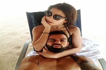 Virat Kohli posted a selfie on Instagram where he can be seen lying with his head on wife AnushkaÃ¢ÂÂs lap, who is sitting on a lounge chair on a sandy beach. In the selfie, which has the appearance of a watercolour painting due to a filter, Anushka flaunts a black bikini and shades. The actress seems to be staring at something while hubby Virat winks an eye looking at the camera and pouts for the selfie.