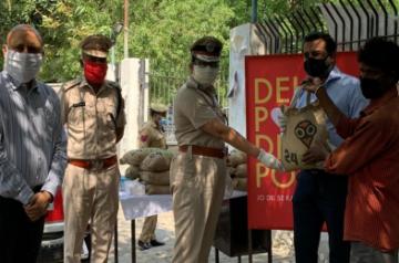 Mr. Samir Modi, Founder and Managing Director, Colorbar with Delhi Police authorites handing out the food relief packages  