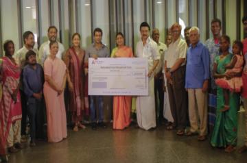 Suriya handing over cheque to Irular.